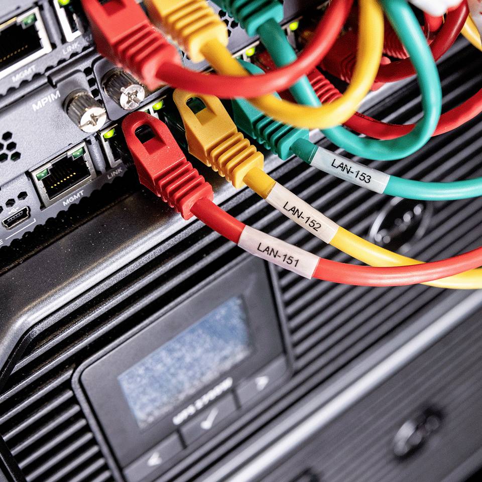 Síťový server připojený několika barevnými ethernetovými kabely, označený štítky LAN-153, LAN-152, LAN-151.