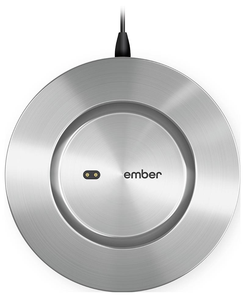 Stříbrný, kulatý nabíjecí adaptér s kabelem na horní straně. Uprostřed je viditelné logo 'ember'.