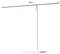 Moderní bílá stolní lampa s elegantním designem. Stínidlo je ploché a široké, zatímco podstavec je minimalisticky řešen.
