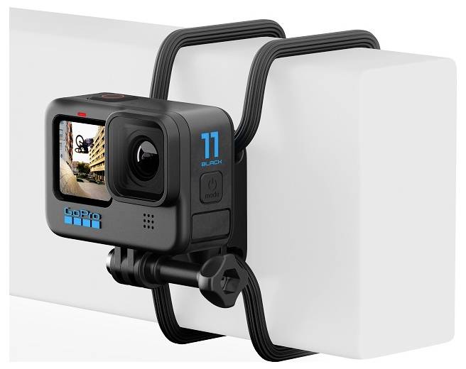 Kamera GoPro je namontována na bílé tyči. Na malém displeji kamery je vidět městská budova.