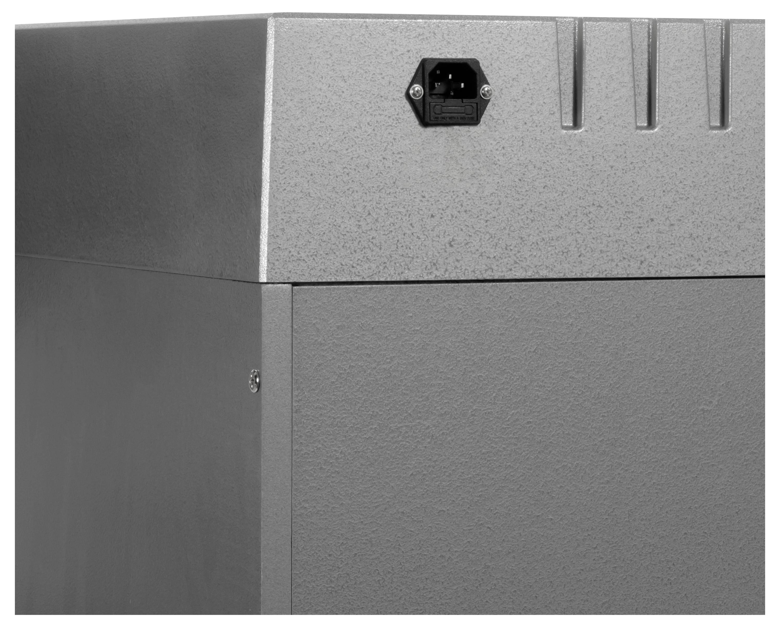 Zblízka fotografovaný šedý kovový elektronický přístroj nebo kryt s přívodním konektorem napájení a ventilačními otvory na přední horní části panelu.