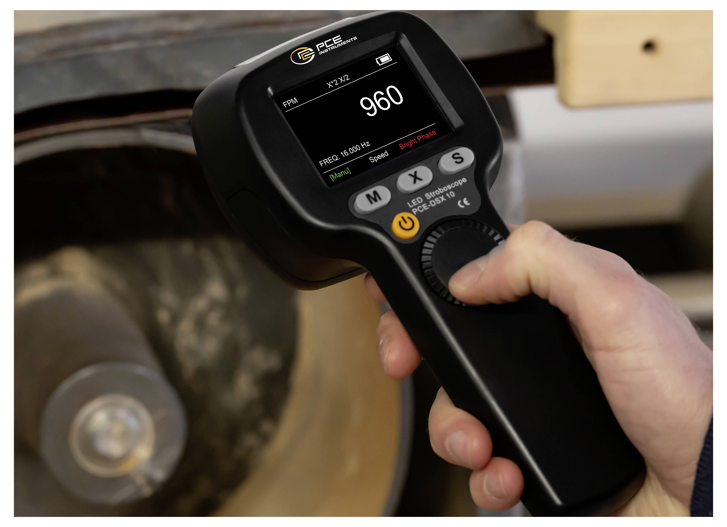 Přenosný digitální otáčkoměr měřící rychlost kola s zobrazením 960 RPM na displeji.