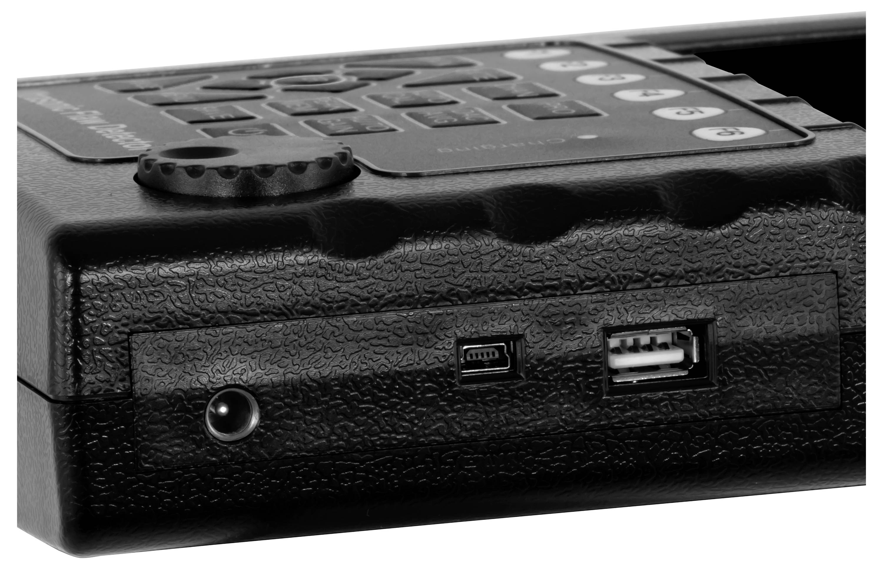 Zblízka černého přenosného zařízení ukazujícího zdrojový konektor a port USB na přední straně.