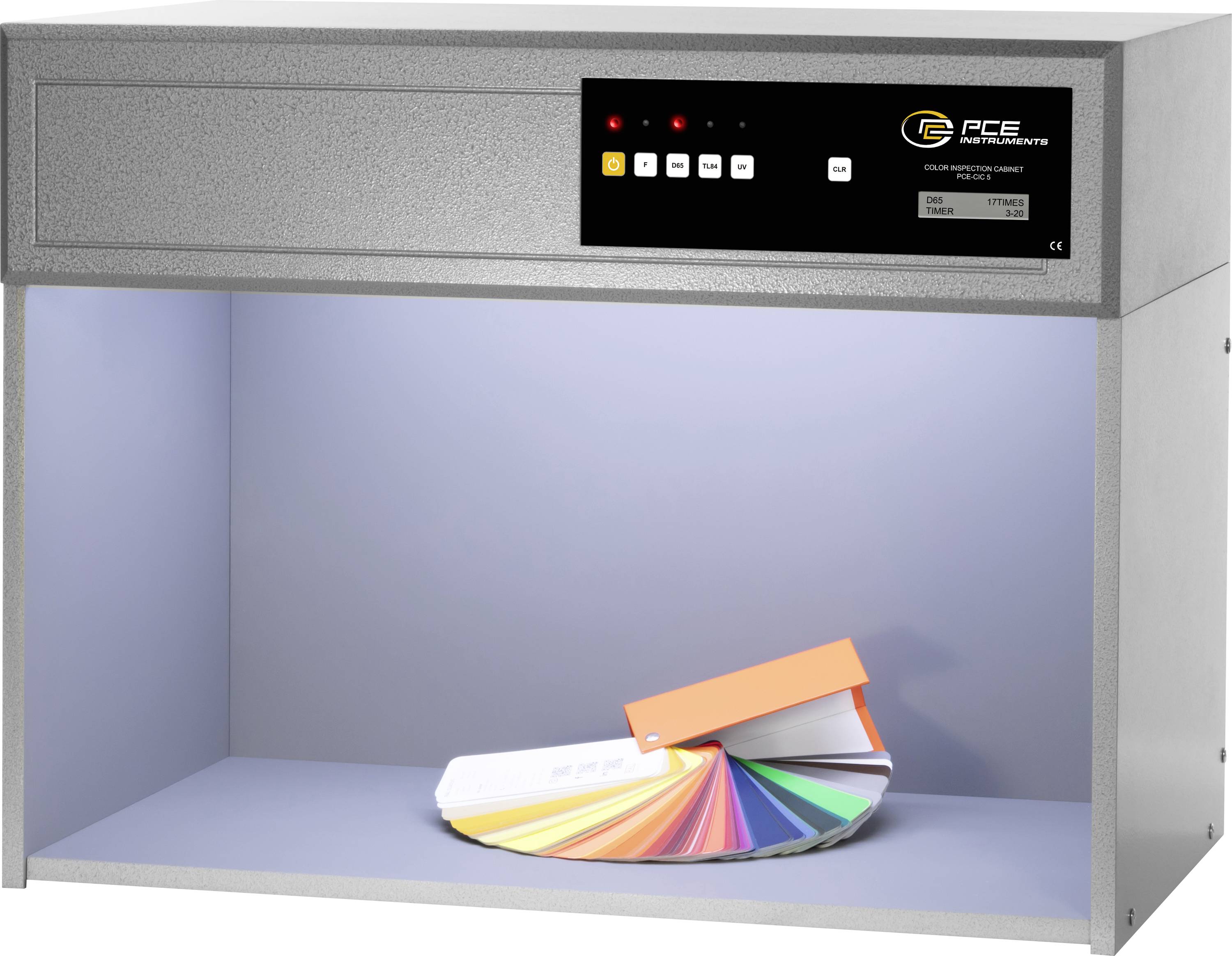 Lampa pro hodnocení barev s vějířem barevných vzorků. Displej zobrazuje světelný režim. Používá se při kontrole barev pro přesnou barevnou reprodukci.