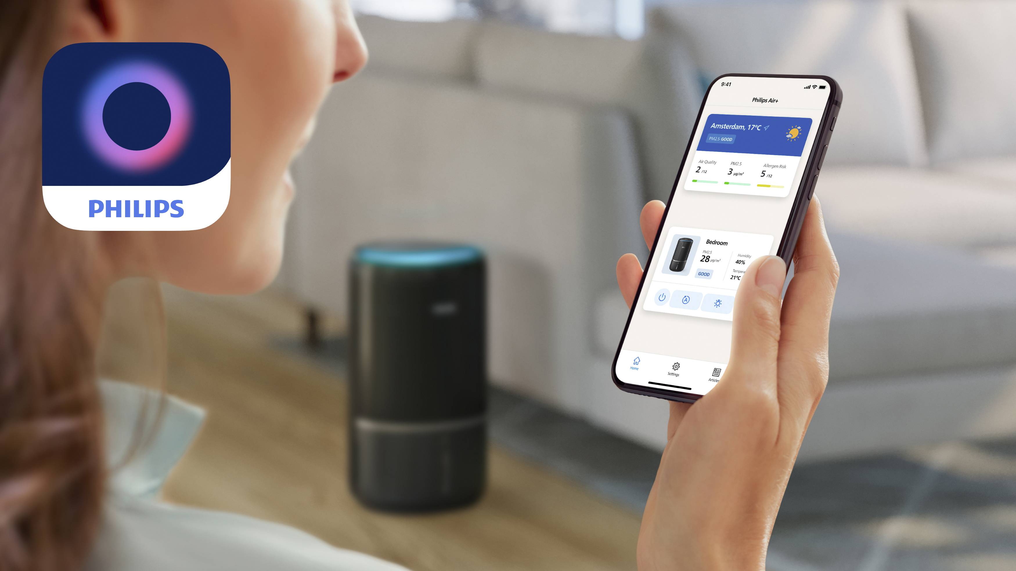 Osoba drží smartphone s aplikací Philips zobrazující údaje o kvalitě vzduchu; v pozadí je čistička vzduchu v obývacím pokoji.