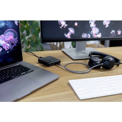 Laptop, monitor a sluchátka na psacím stole. Monitor zobrazuje obrázky medúz, pracovní prostředí působí moderně a uspořádaně.