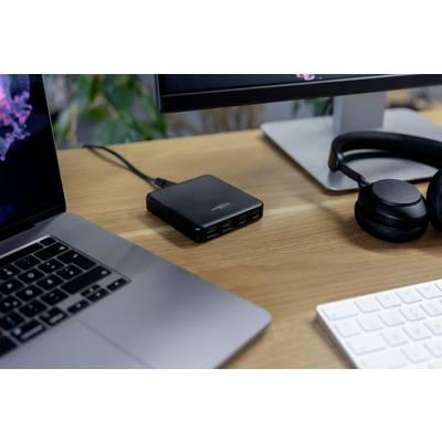 Na psacím stole stojí laptop, monitor, sluchátka a multifunkční USB nabíjecí stanice. Technologické pracoviště.