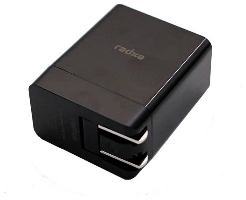 Černá, obdélníková nabíječka se dvěma USB porty, s názvem značky nahoře. Ideální pro současné nabíjení několika zařízení.