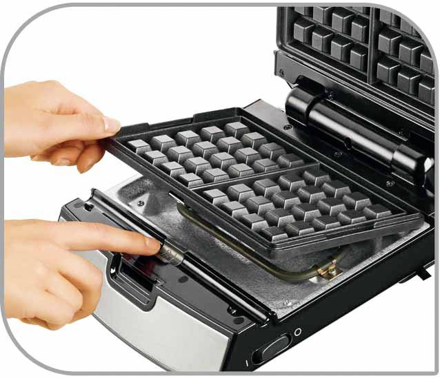 Jedna osoba odstraňuje mřížku z vaflovače, aby přístroj vyčistila. Jiný prst ukazuje na místo západky.