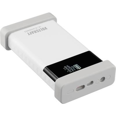 Přenosná bílá a černá powerbanka značky 'VOLTCRAFT' s digitálním displejem zobrazujícím stav nabití. Vybavena USB porty.