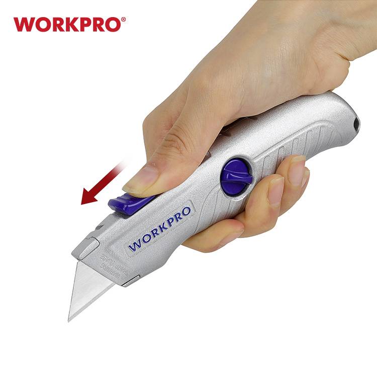 Jedna ruka drží stříbrný vysouvací řezák značky 'WORKPRO'. Červený šipka ukazuje pohyb čepele.