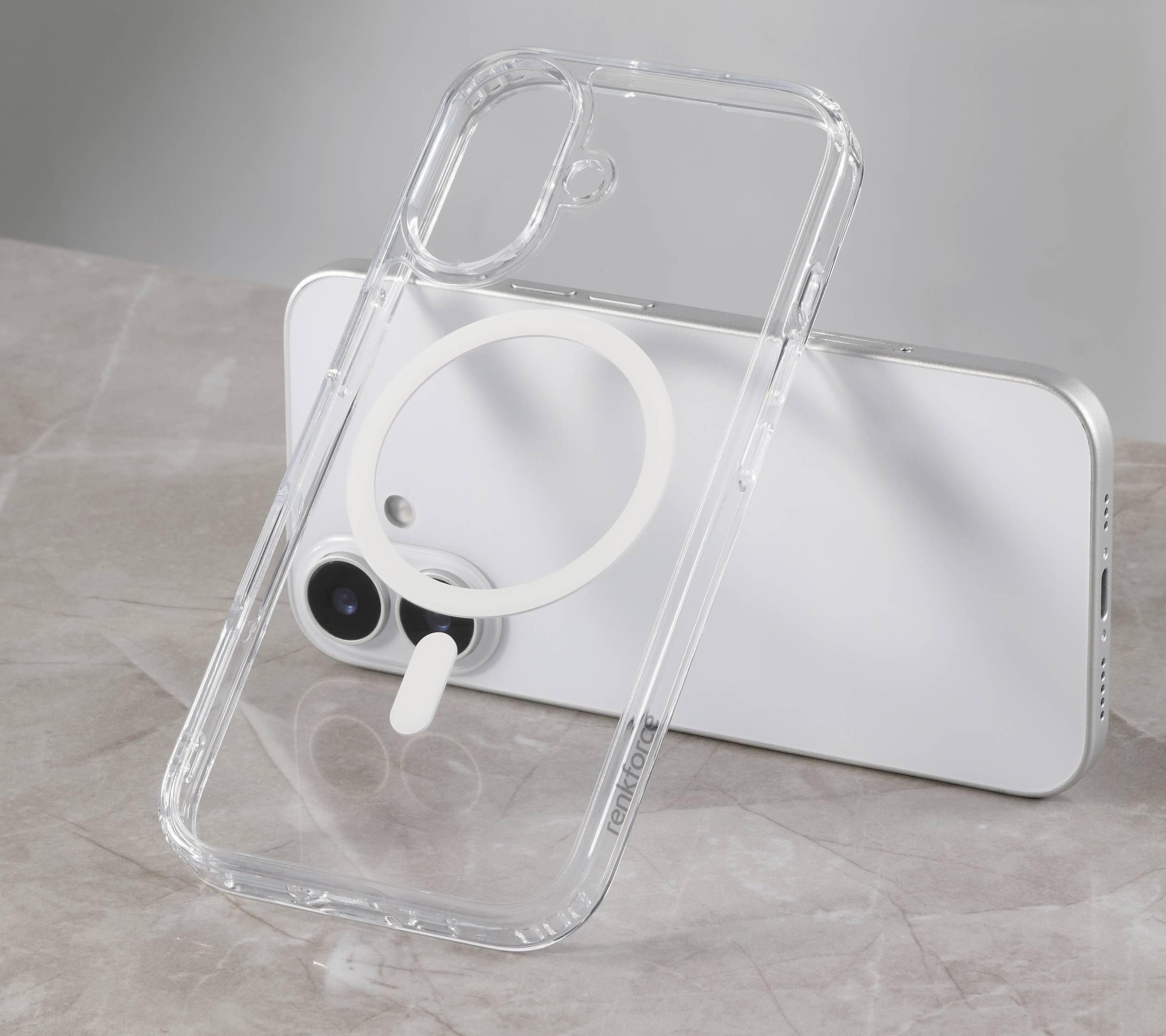 Smartphone v průhledném obalu s kruhovým magnetem na mramorovém stole.