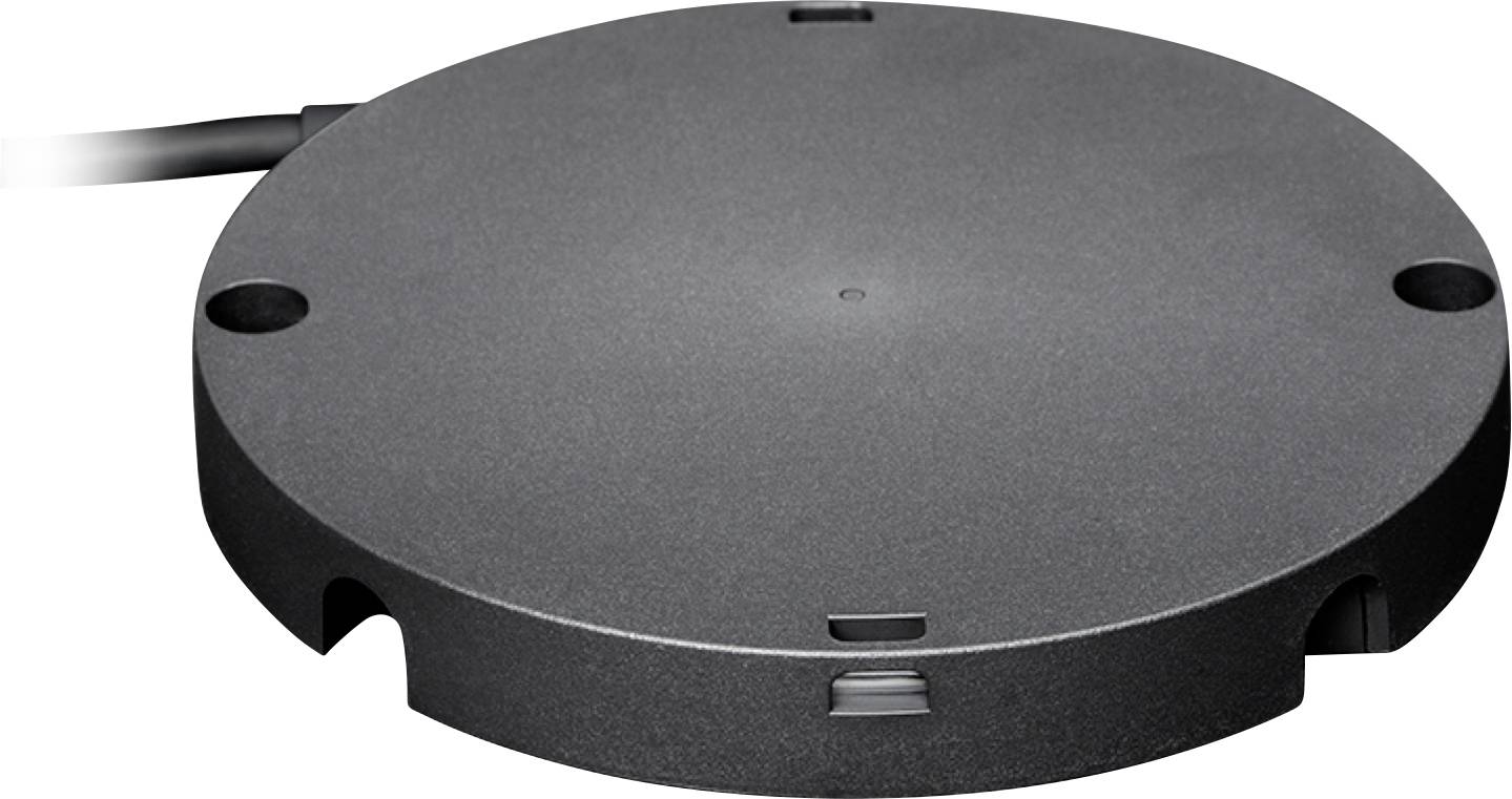 Kulatá, černá nabíjecí základna s přípojným otvorem na straně, vhodná pro bezdrátové nabíjení zařízení.