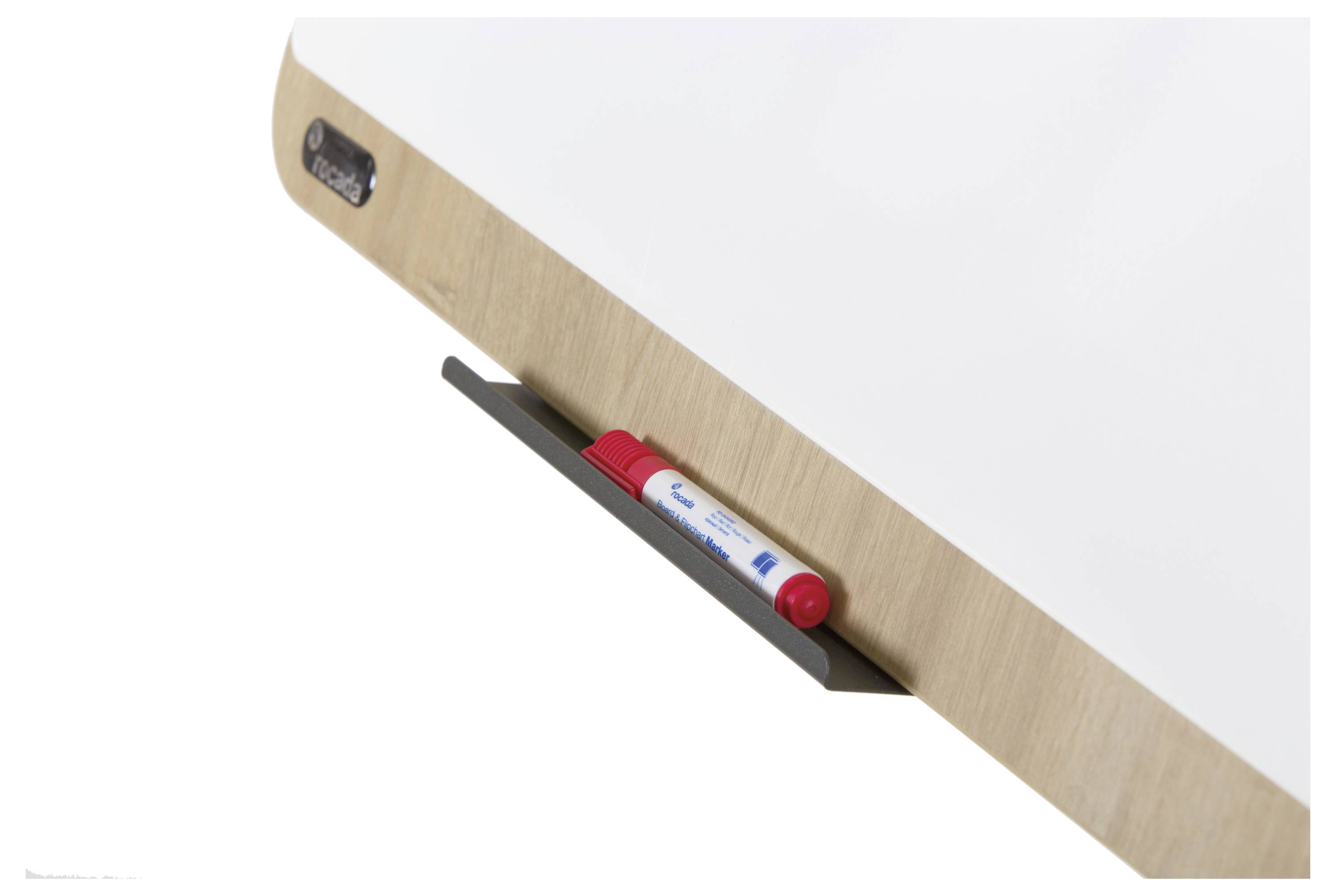 Fix je umístěn v držáku na dřevěném rámu bílé tabule.