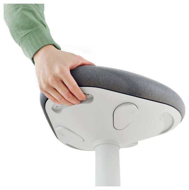 Ruka nastavuje výšku šedé ergonomické židle pomocí tlačítka umístěného pod sedací plochou.