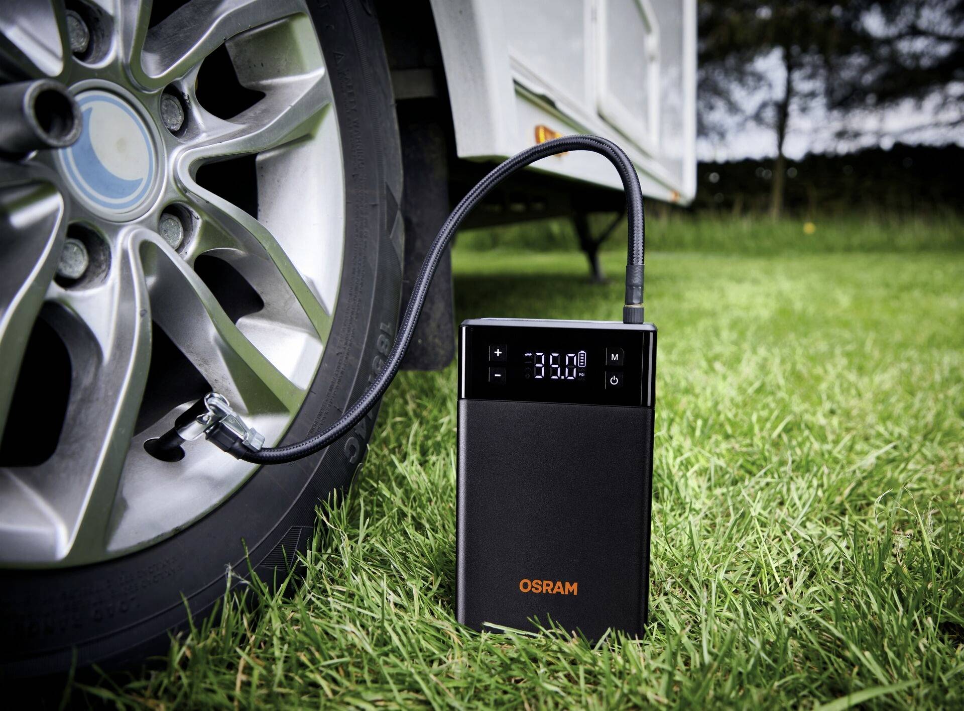 OSRAM vzduchový kompresor nafukuje pneumatiky; zobrazuje tlak 33,0 PSI na displeji.