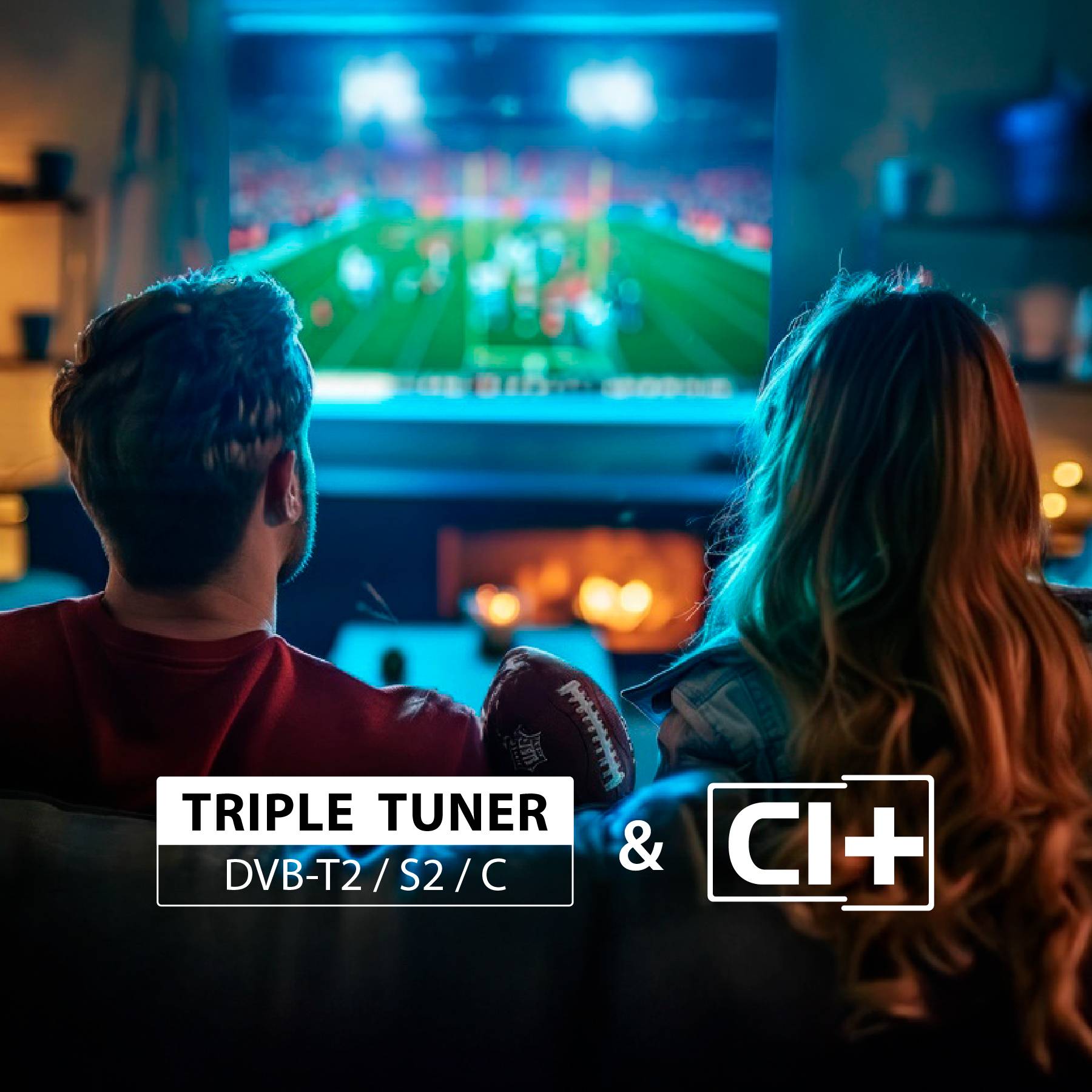 Dva lidé sledují fotbalový zápas v televizi v útulném obývacím pokoji. Zvýrazněný text: „Triple Tuner DVB-T2/S2/C a CI+".