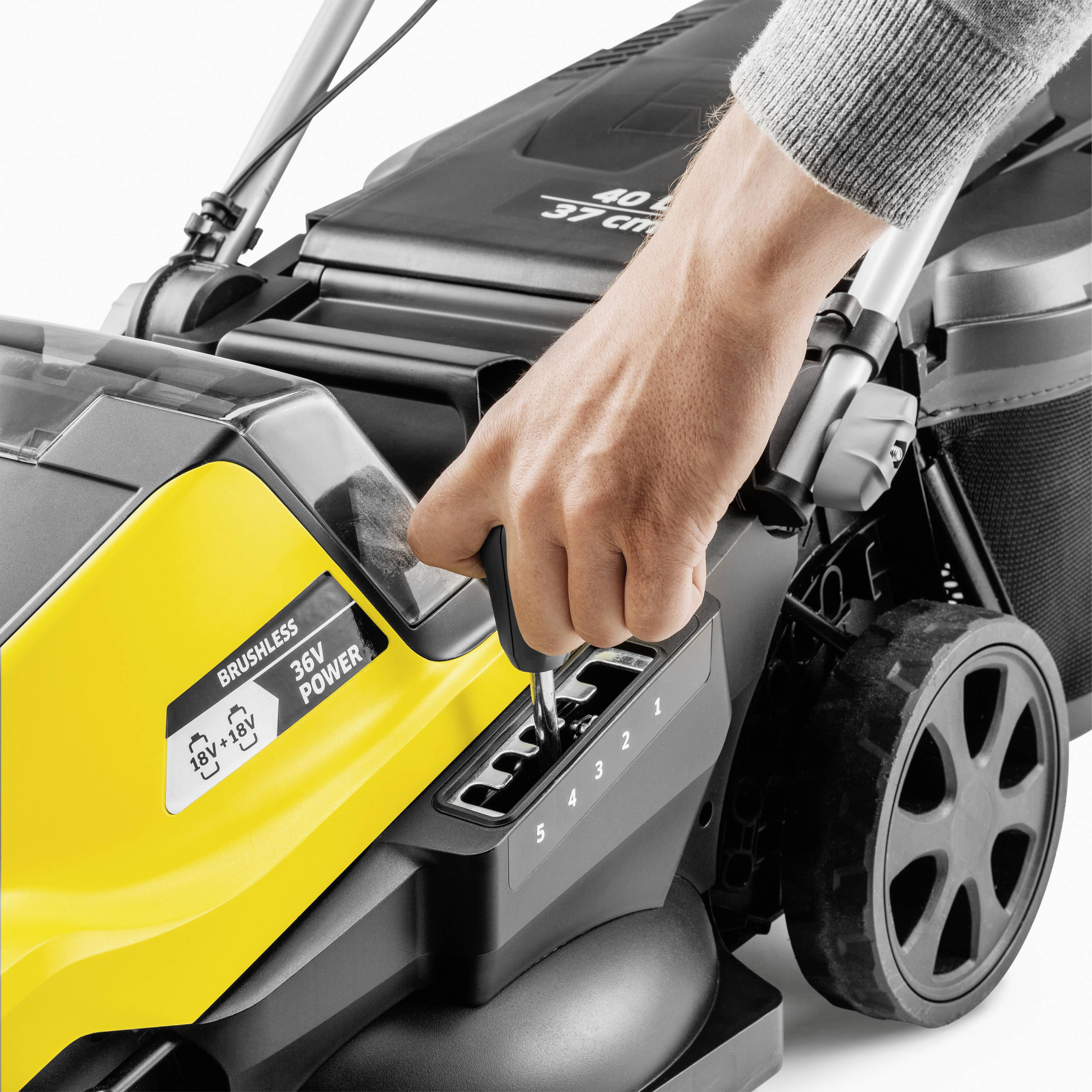 Ruka nastavuje výšku sečení žlutého sekačky s šesti stupni nastavení. Sekačka je částečně elektrická.