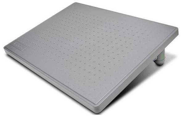 Šedá, šikmá opěrka nohou s reliéfním povrchem, která podporuje ergonomické sezení v kanceláři.