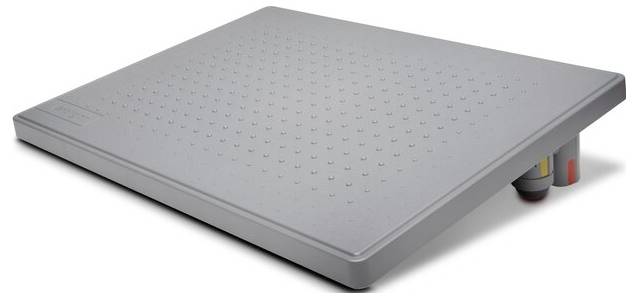 Šedá, mírně skloněná opěrka nohou s protiskluzovým povrchem, ideální pro podporu ergonomického sedu u psacího stolu.