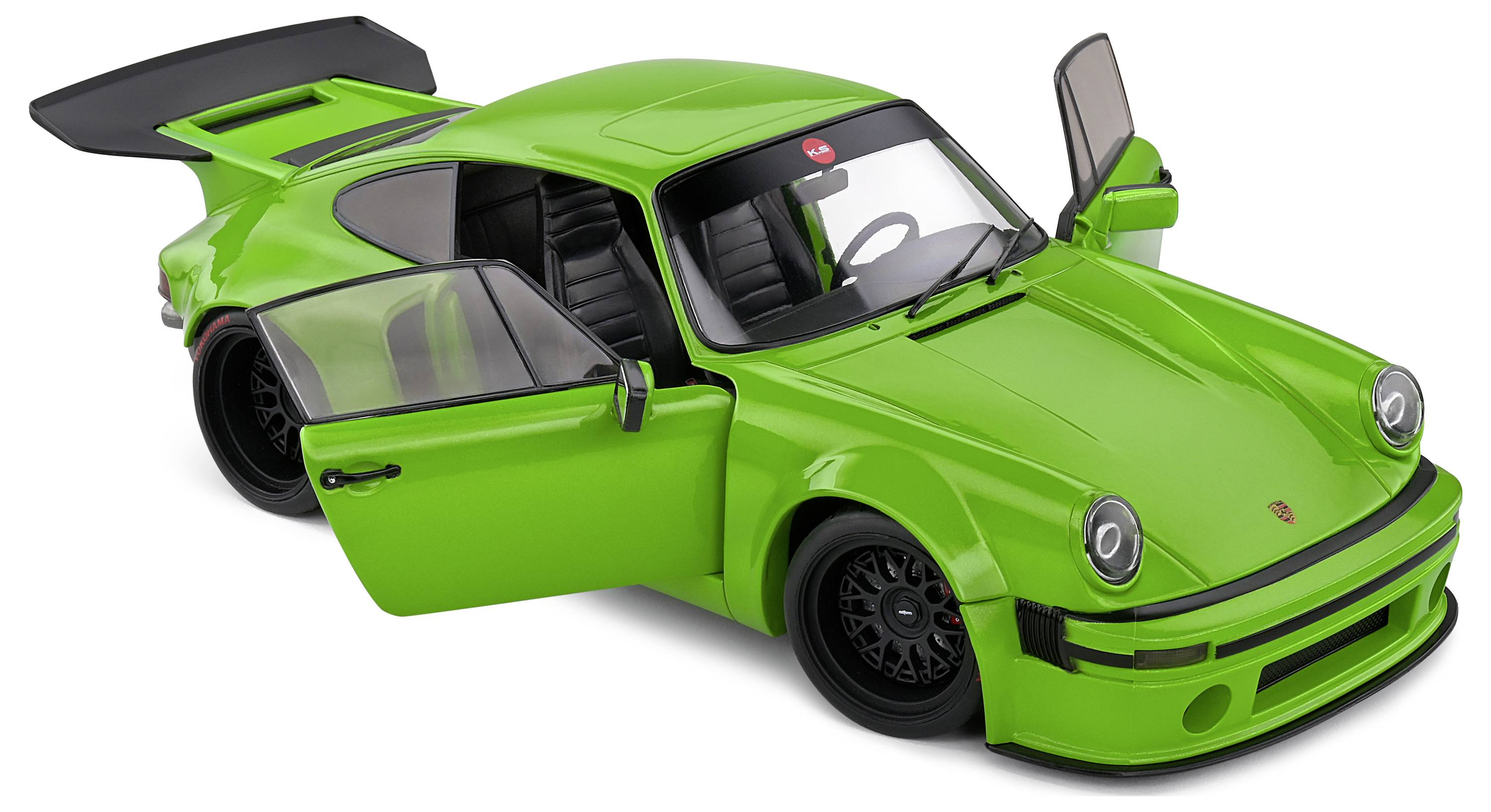 Zelené modelové auto Porsche 911 s otevřenými dveřmi, pohled z předního šikmého úhlu.