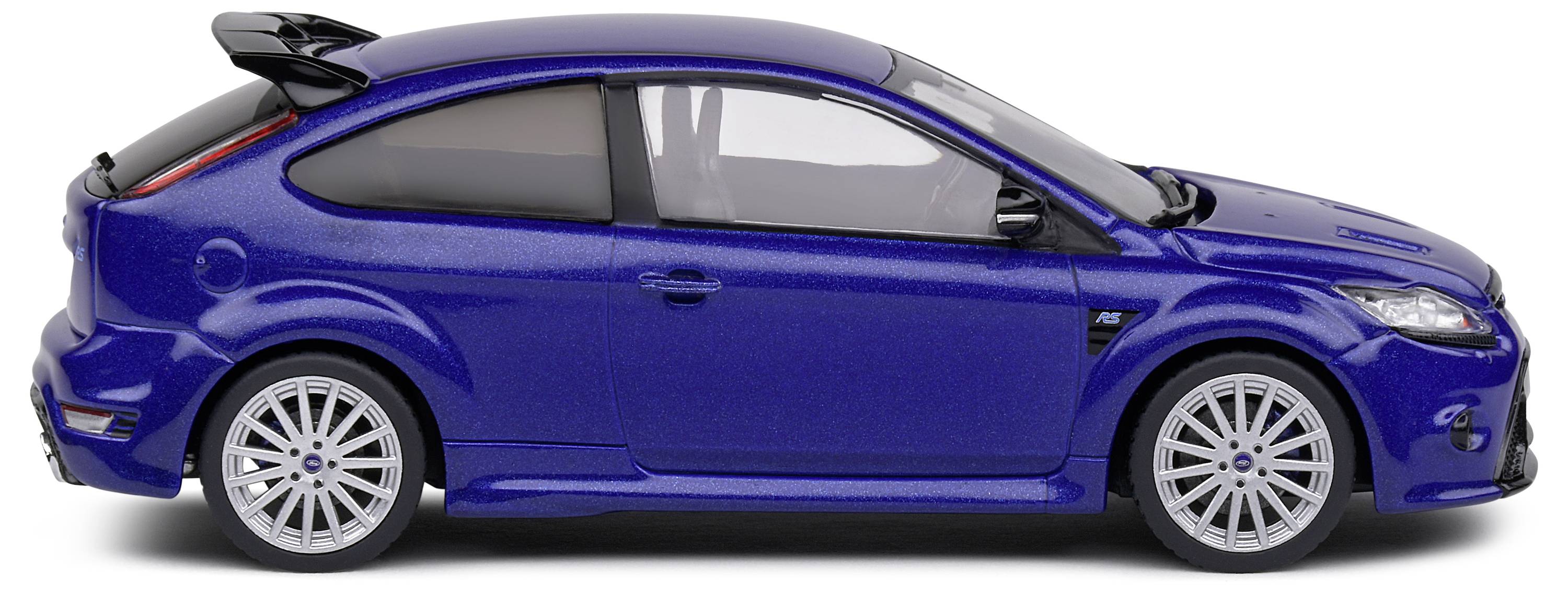 Tmavě modré modelové auto z bočního pohledu, sportovní hatchback se spoilerem a stříbrnými ráfky, na bílém pozadí.