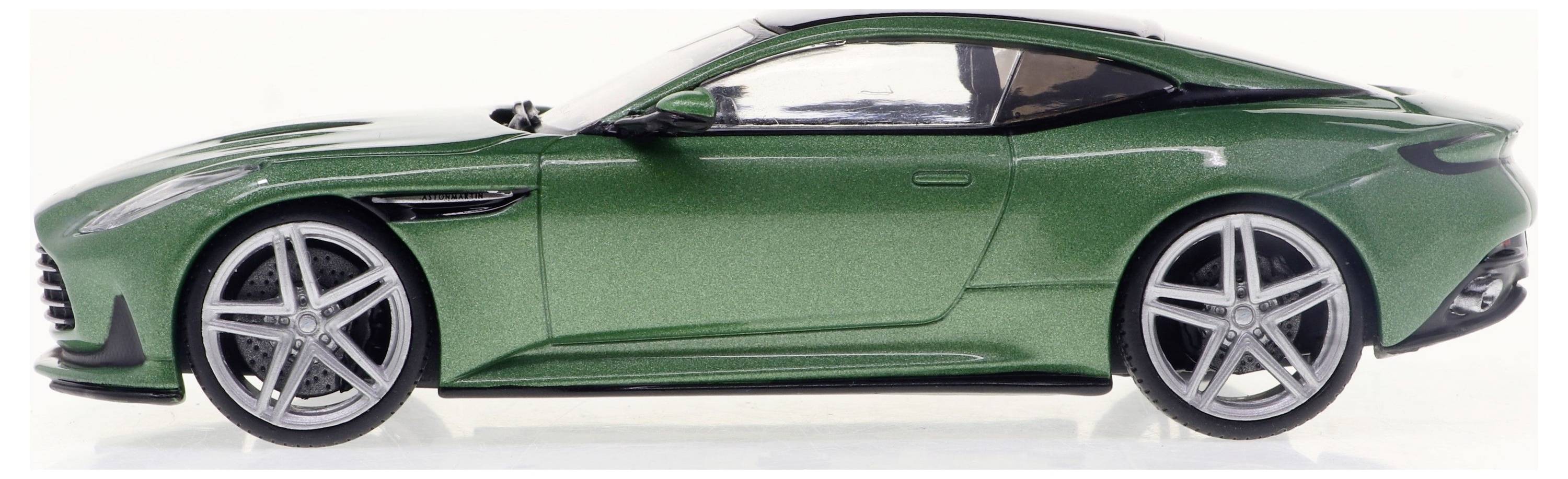 Zelené hračkové auto z boku, ukazující aerodynamický design s stříbrnými ráfky a sportovní karoserií.