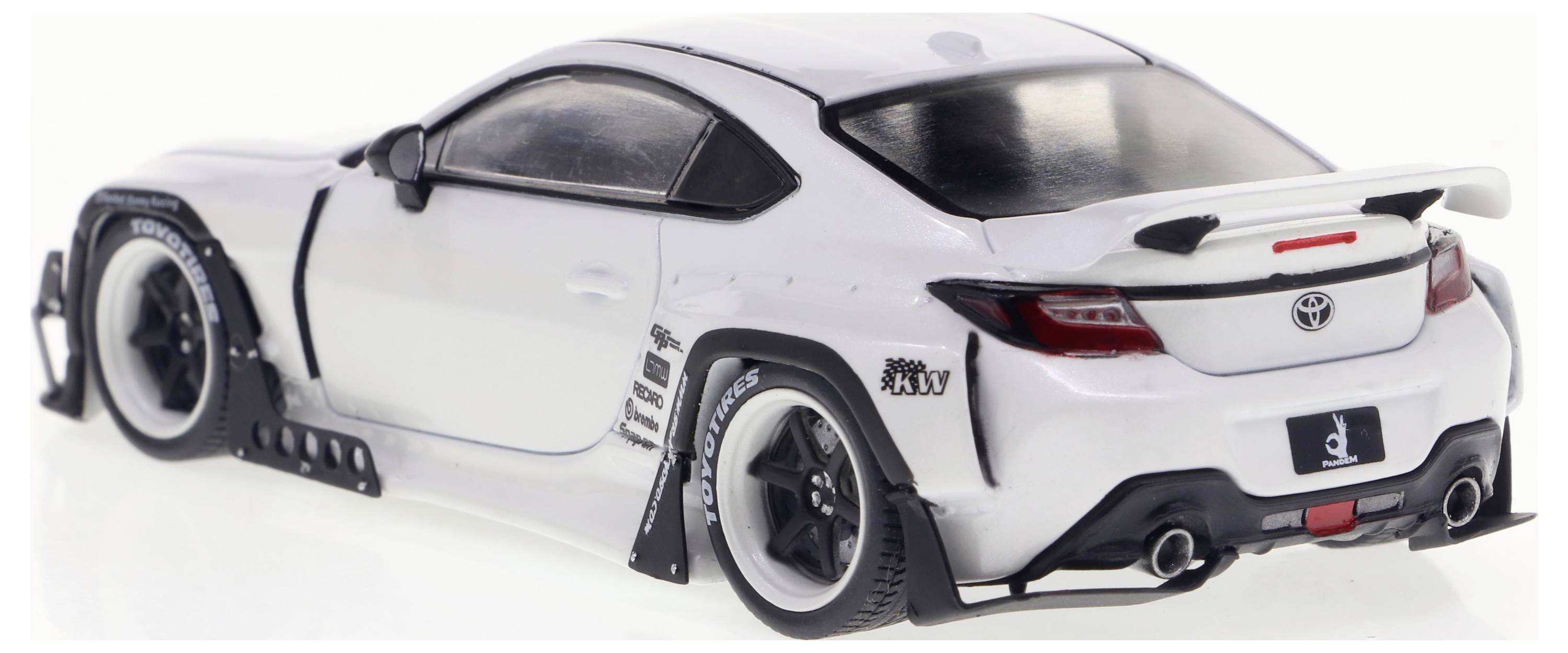 Model auta v bílé barvě s bodykit sadou a zadním křídlem. Detailně zpracované pneumatiky a samolepky na bocích, zvýrazněný pohled zezadu.