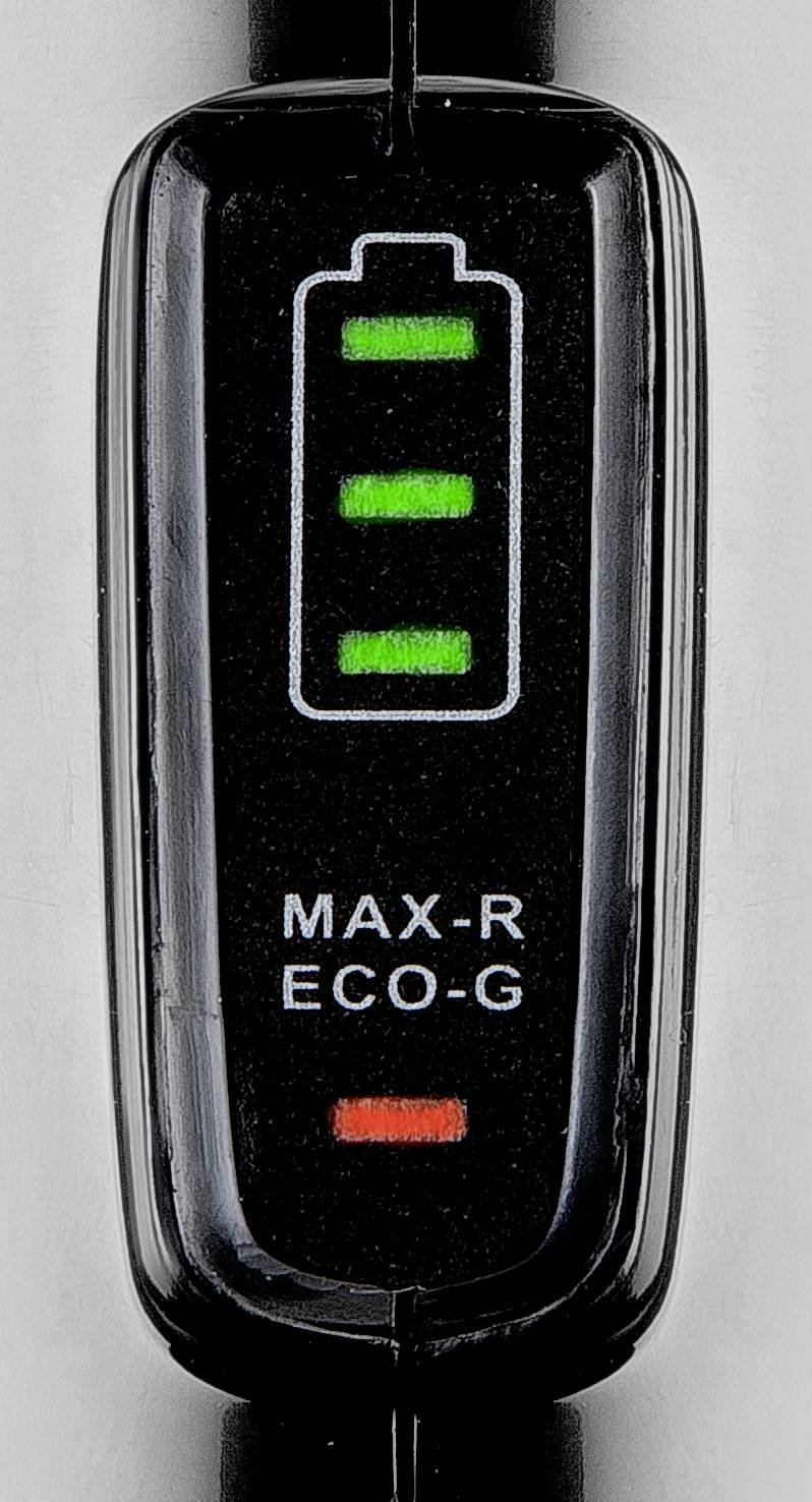 Detailní záběr nabíjecího indikátoru se třemi zelenými svítícími sloupci a jedním červeným sloupcem, vedle nápis 'MAX-R ECO-G'.