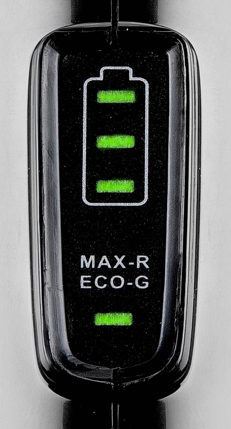 Detailní záběr černého indikátoru stavu nabití s zelenými svítícími pruhy a označením 'MAX-R' a 'ECO-G'.