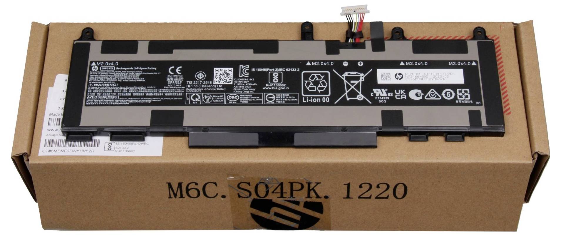 Laptop baterie na kartonu s technickými specifikacemi a štítky. Baterie je lithium-iontový model s různými bezpečnostními a recyklačními symboly.
