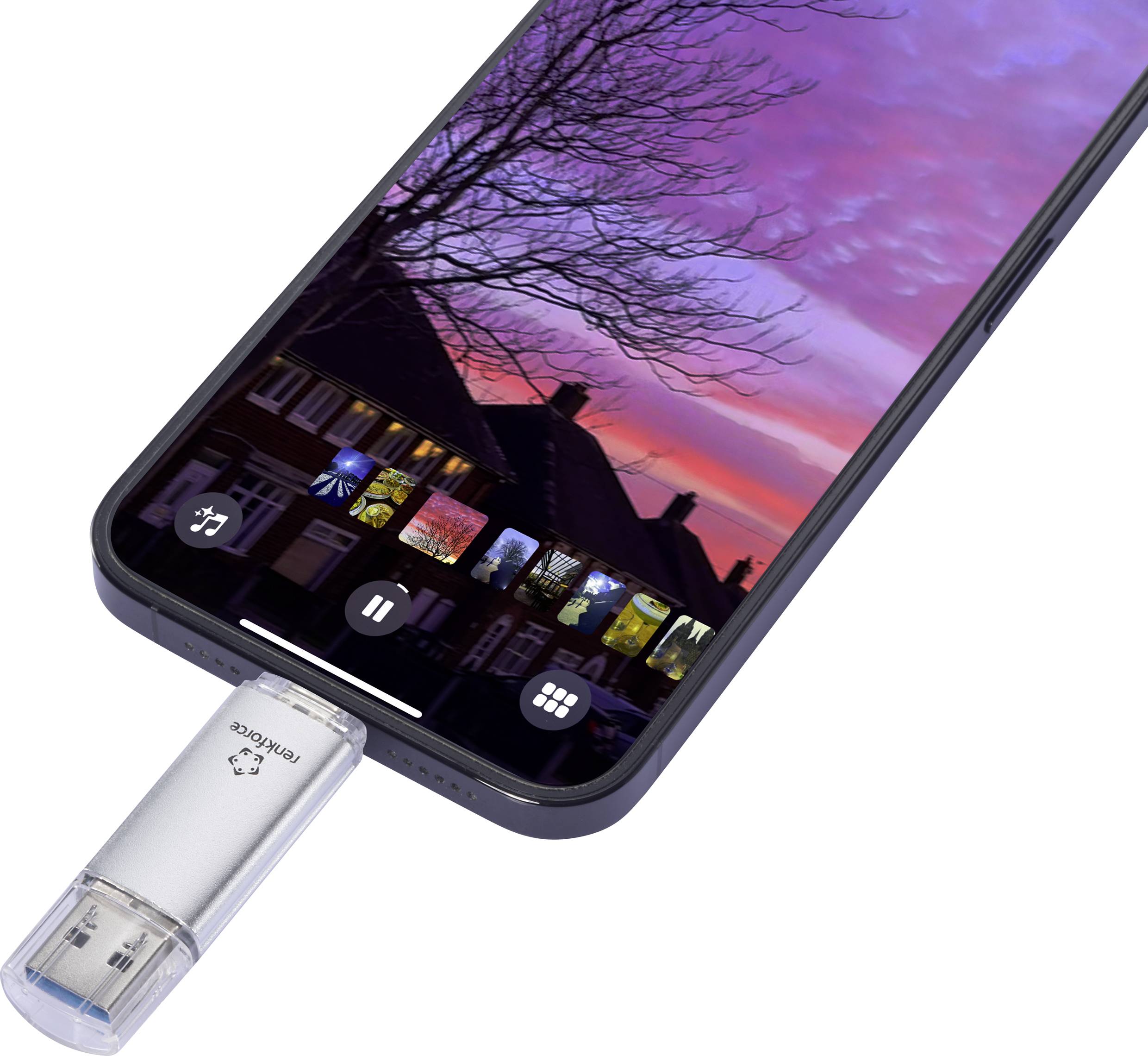 Smartphone s připojeným USB diskem zobrazuje na displeji fotografie západu slunce nad domy a stromy.