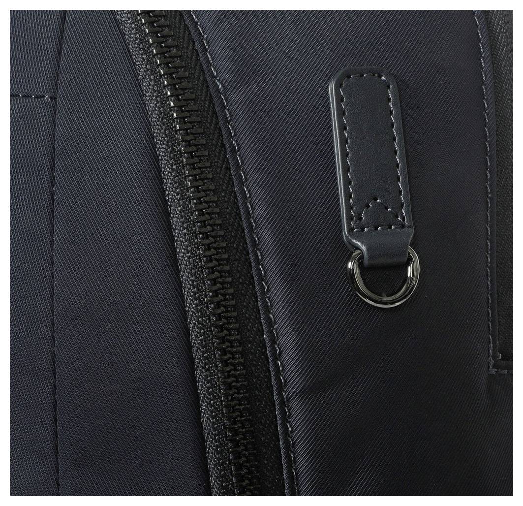 Detailní záběr černého zipu na tašce, ukazující detail jezdce a strukturu látky.