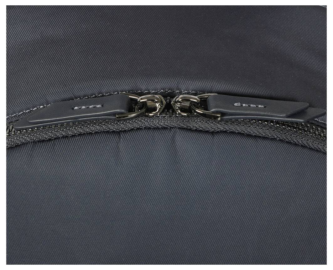 Černý zip v detailním záběru, zavřený. Povrch materiálu je hladký a tmavý.