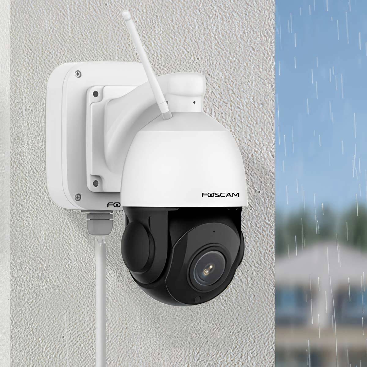Bezpečnostní kamera Foscam namontovaná na zdi, s deštěm v pozadí, demonstrující odolnost vůči povětrnostním vlivům.