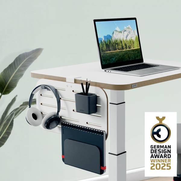 Výškově nastavitelný psací stůl s integrovaným příslušenstvím a notebookem, oceněný cenou 'German Design Award Winner 2023'.