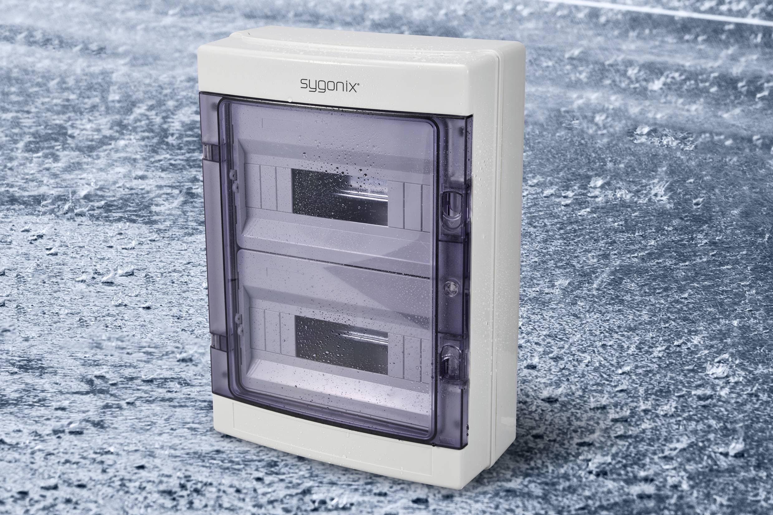 Vodotěsné pouzdro s průhledným, uzavíratelným víkem na zledovatělém povrchu. Ideální pro venkovní elektrické instalace.