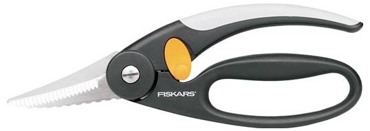 Černé a oranžové nůžky Fiskars se zoubkovanou čepelí, vhodné do kuchyně nebo na zahradu.