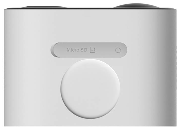 Šedé zařízení s velkým, kulatým tlačítkem uprostřed a slotem na microSD kartu a symbolem napájení nahoře.