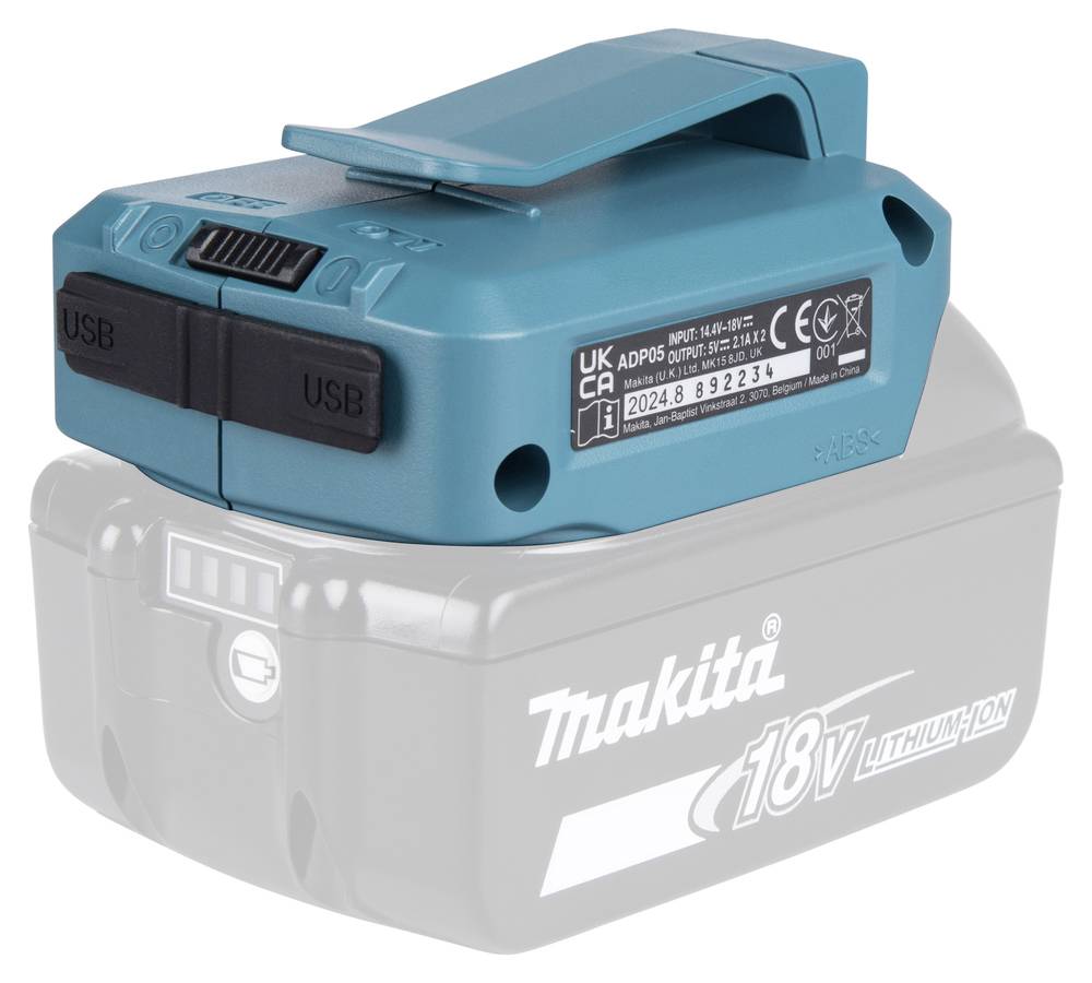 Modrý tyrkysový USB adaptér umístěný na šedém akumulátorovém balíčku Makita 18V lithium-iontové baterie, zobrazující dva USB porty a bezpečnostní certifikační štítky.