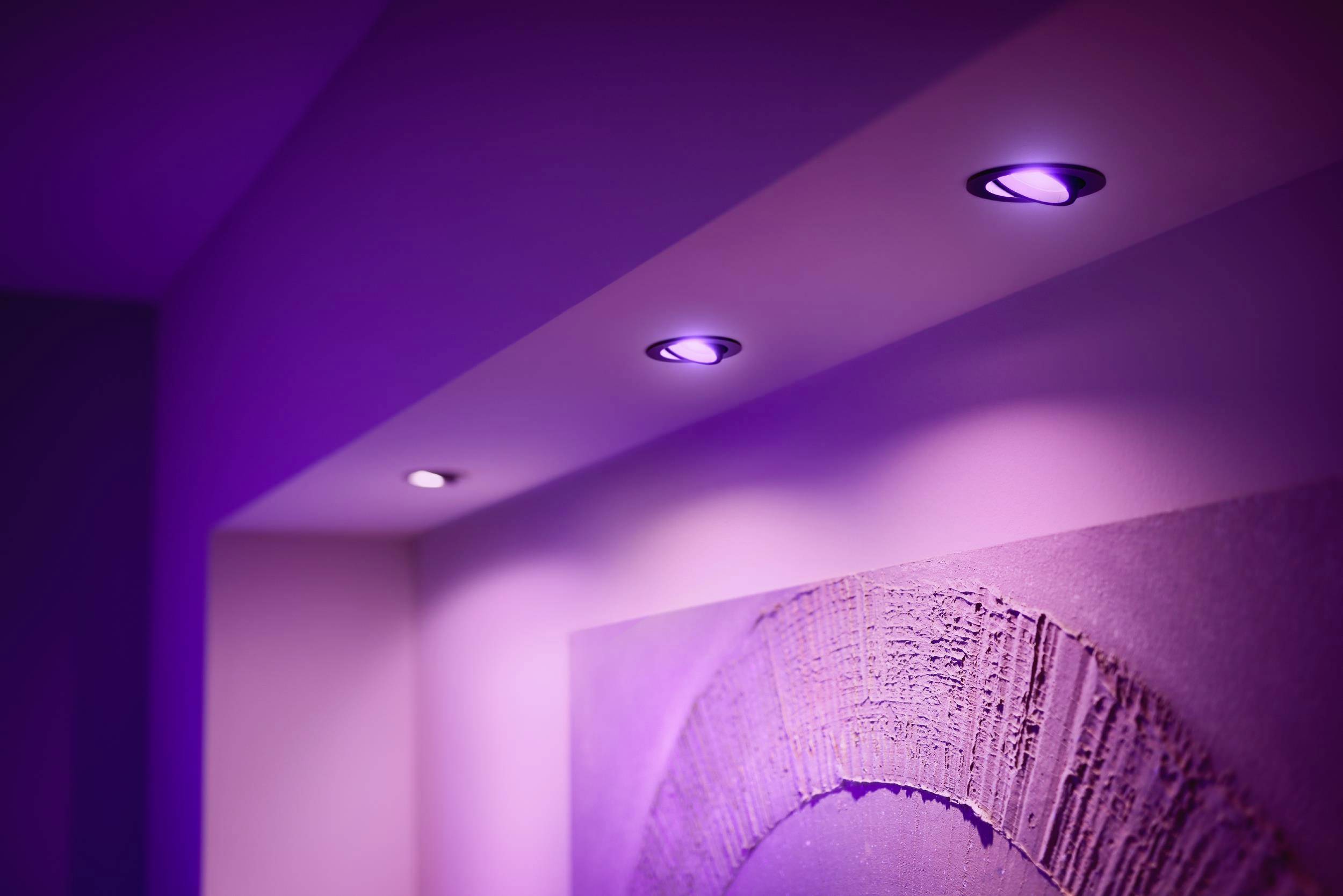 Fialové LED osvětlení ve stropě částečně osvětluje moderní nástěnný obraz. Atmosférické, futuristické řešení interiéru.