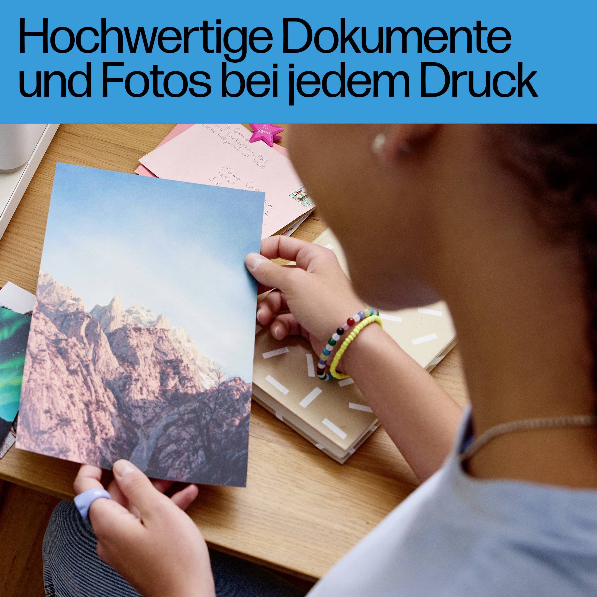 Osoba drží fotografii hor. Text v obraze: 'Vysoce kvalitní dokumenty a fotografie při každém tisku'.