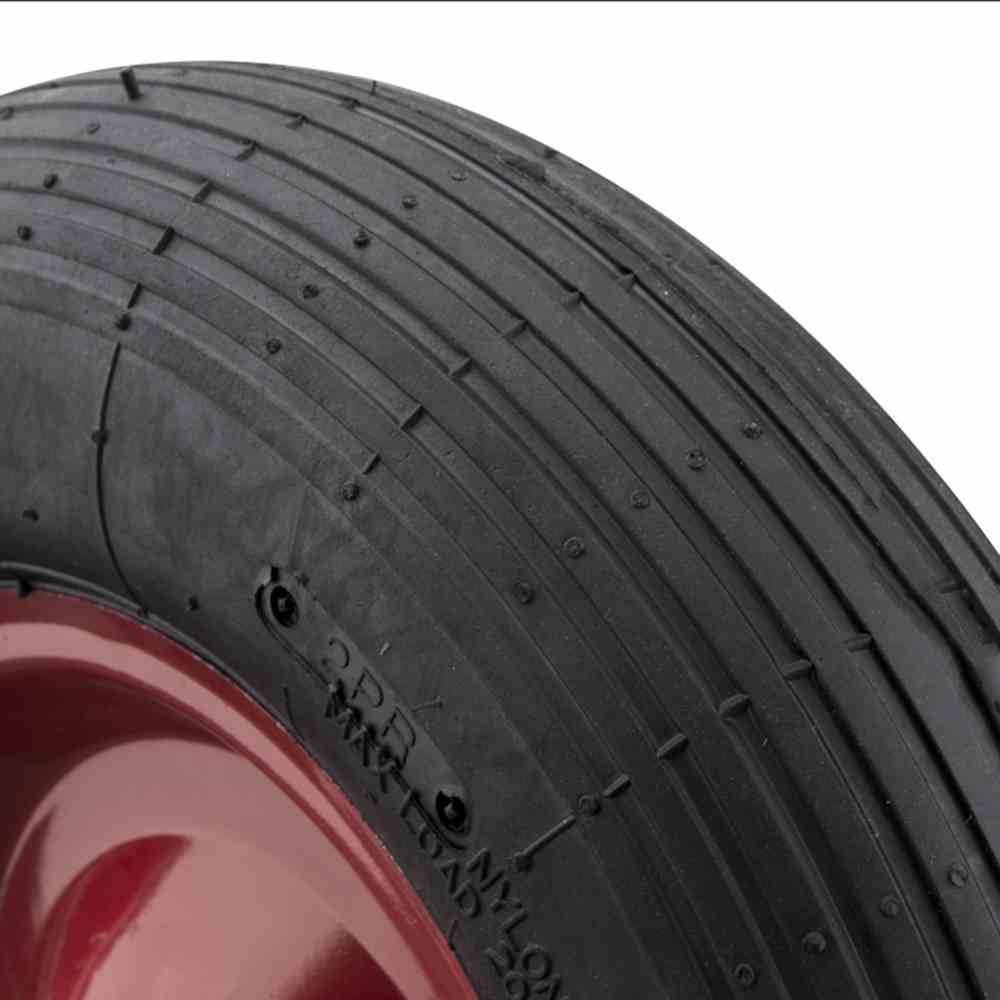 Detailní záběr pneumatiky automobilu s červeným okrajem ráfku. Pneumatika má jednoduché dezénové vzory a viditelné nápisy.