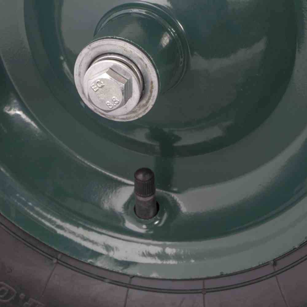Detailní záběr pneumatiky automobilu s ventilem a kolovou maticí na kovovém ráfku.