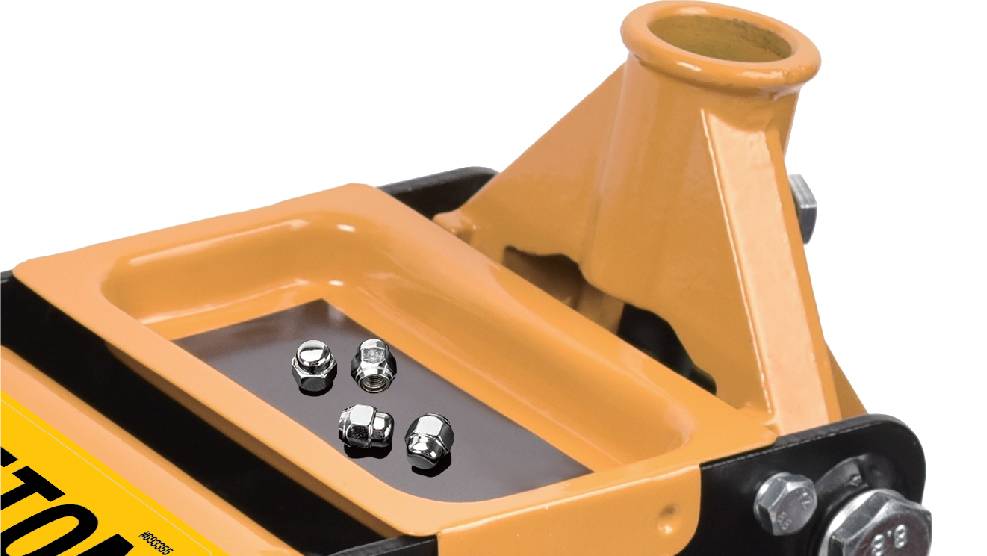 Detailní záběr žlutého hydraulického zvedáku se čtyřmi kovovými maticemi odpočívajícími na rovném povrchu.