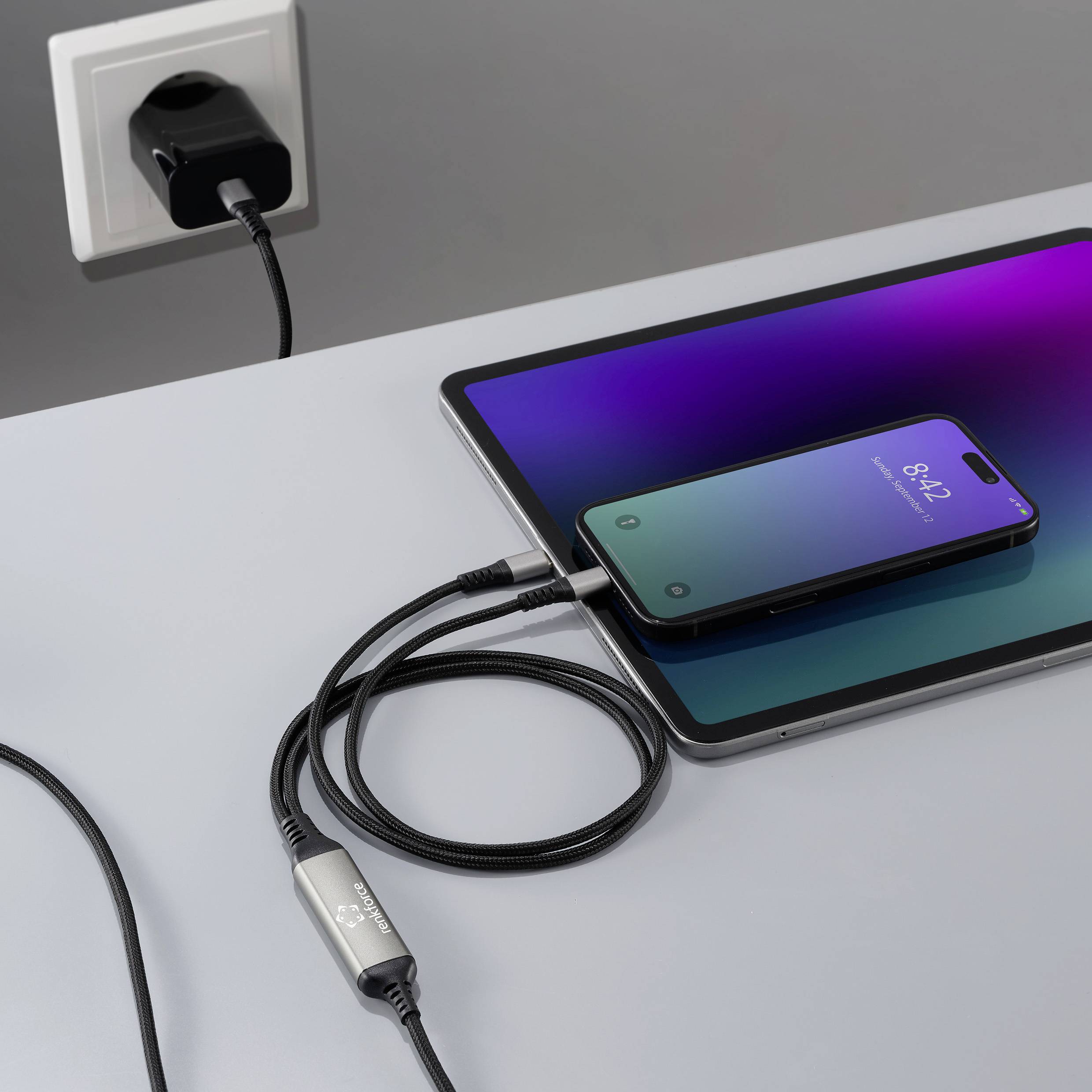 Smartphone se nabíjí na tabletu, který je připojen k elektrické zásuvce. Obě zařízení zobrazují na svých obrazovkách indikátory nabíjení.