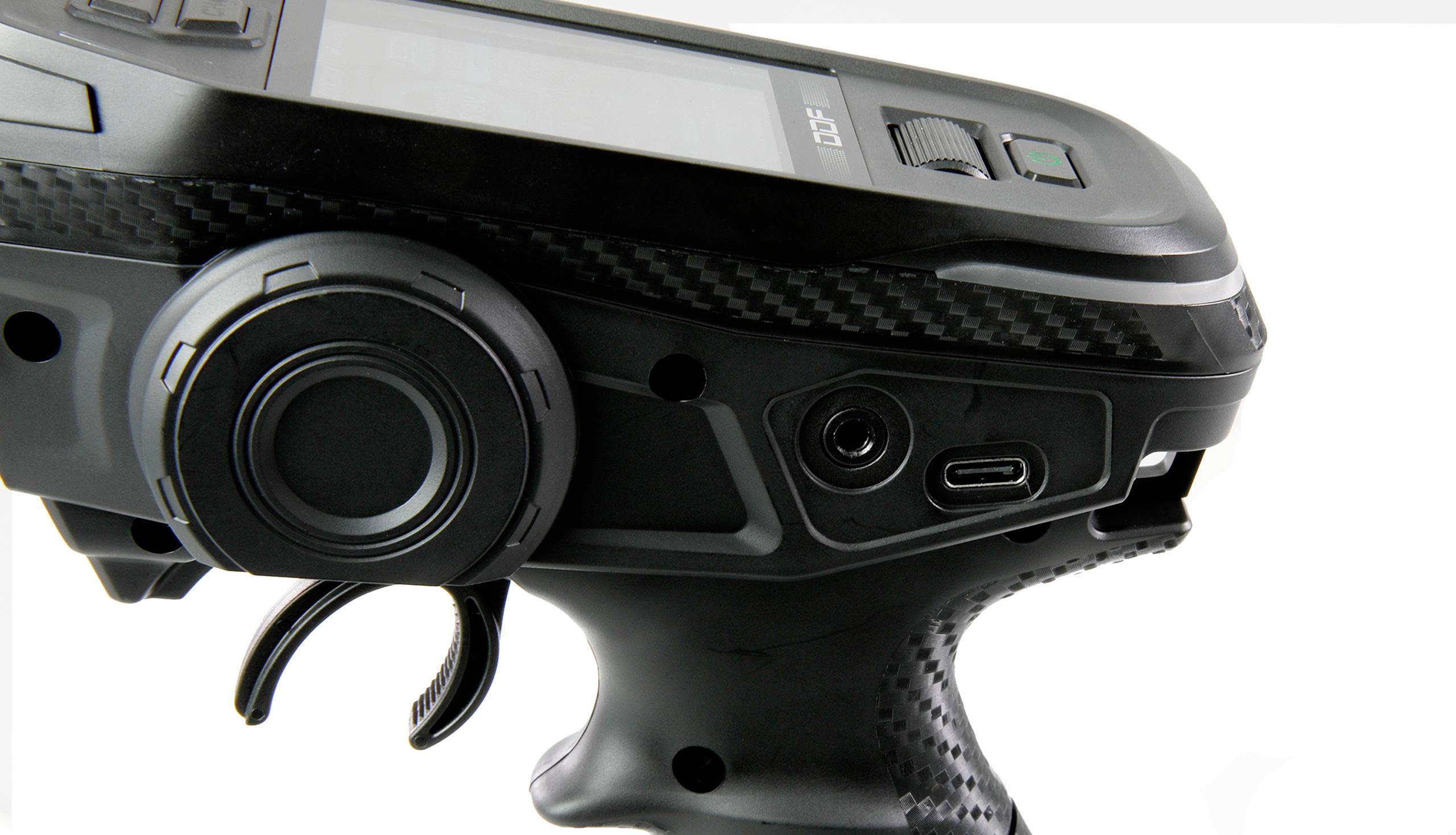 Detailní záběr černého ergonomického ovládacího zařízení s několika tlačítky a otočným knoflíkem, pravděpodobně určeného pro dálkové ovládání.
