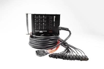 Černá stagebox s několika vstupy, dlouhými kabely a přípojkami. Používá se pro připojení audio zařízení v événtové technice.