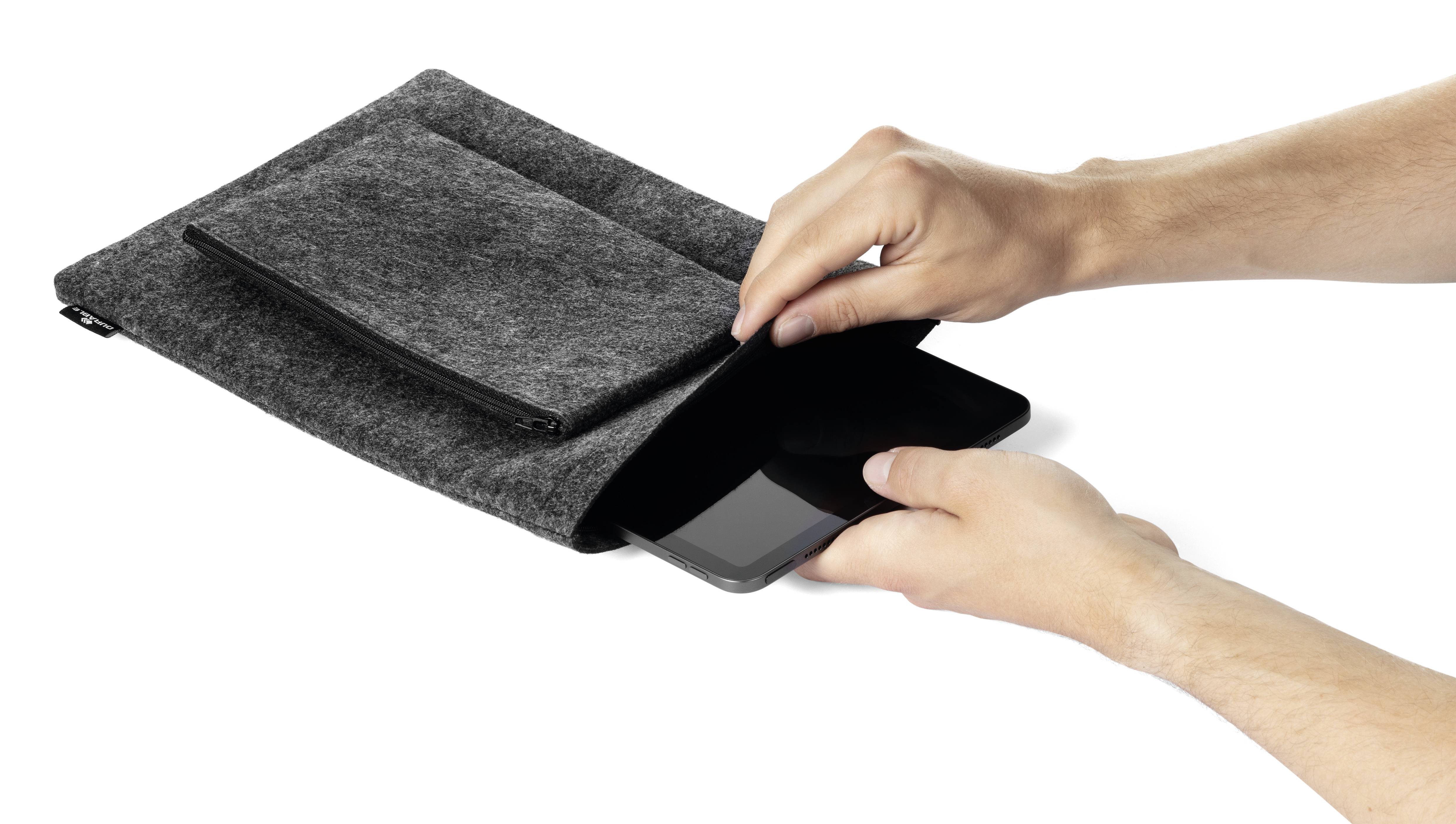 Osoba vkládá tablet do šedého plstěného obalu s kapsou, pravděpodobně za účelem ochrany nebo uložení zařízení.