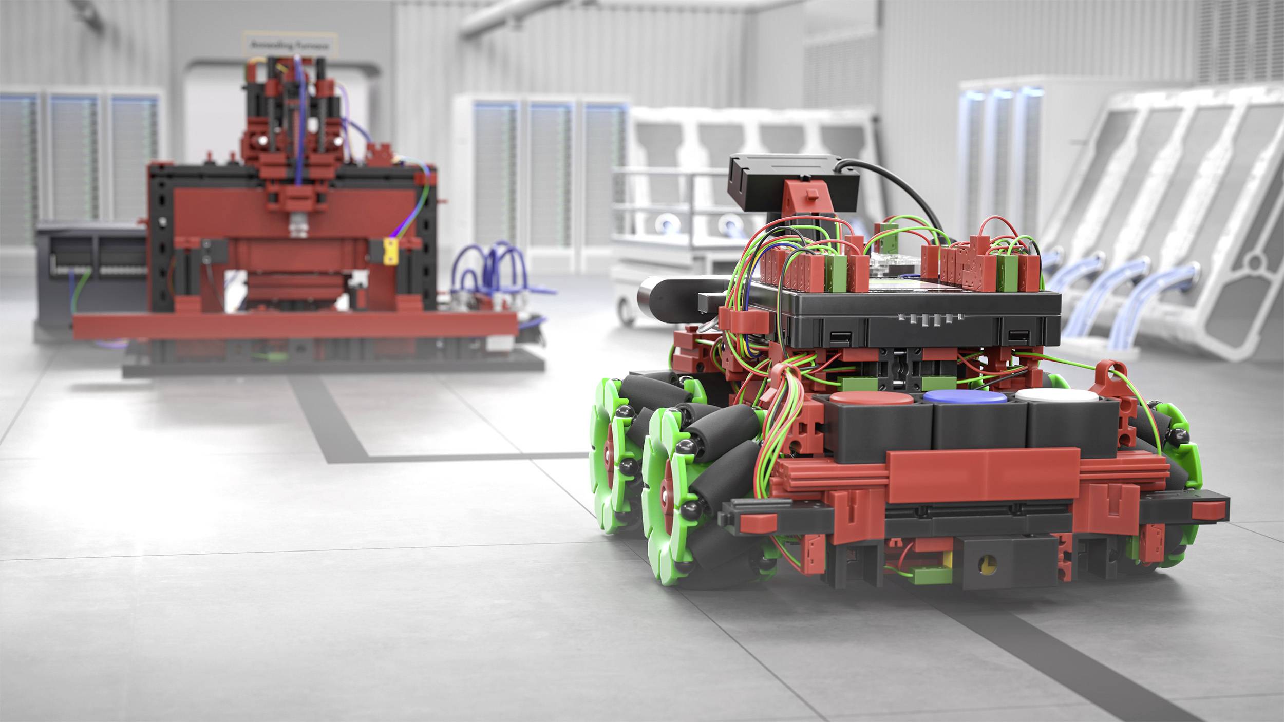 Červené robotické vozidlo se zelenými koly stojí v high-tech laboratoři. V pozadí se nachází velký stroj.